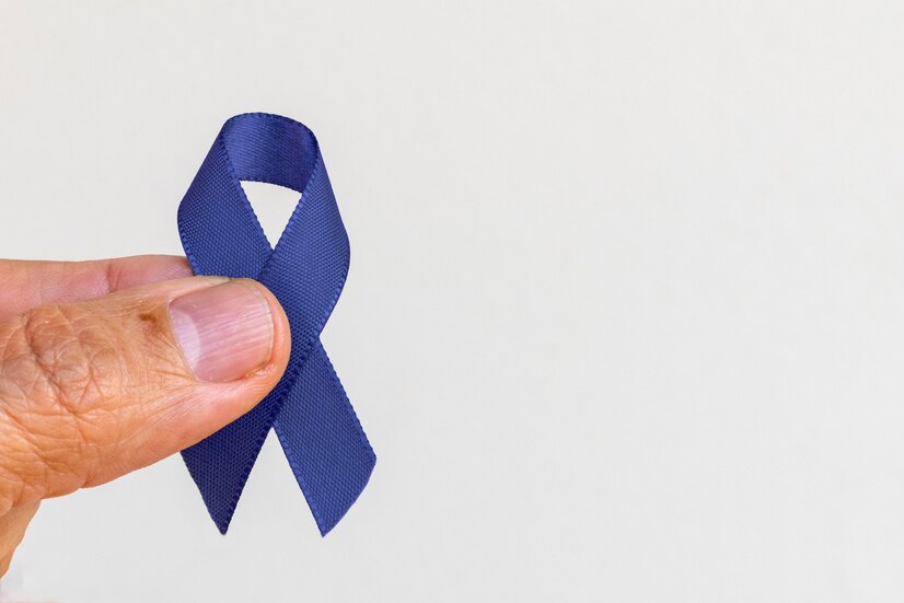 mao-segurando-uma-fita-azul-sobre-fundo-branco-cancer-colorretal-conscientizacao-do-cancer-de-prostata-conscientizacao-da-saude-masculina-novembro-azul_146714-209