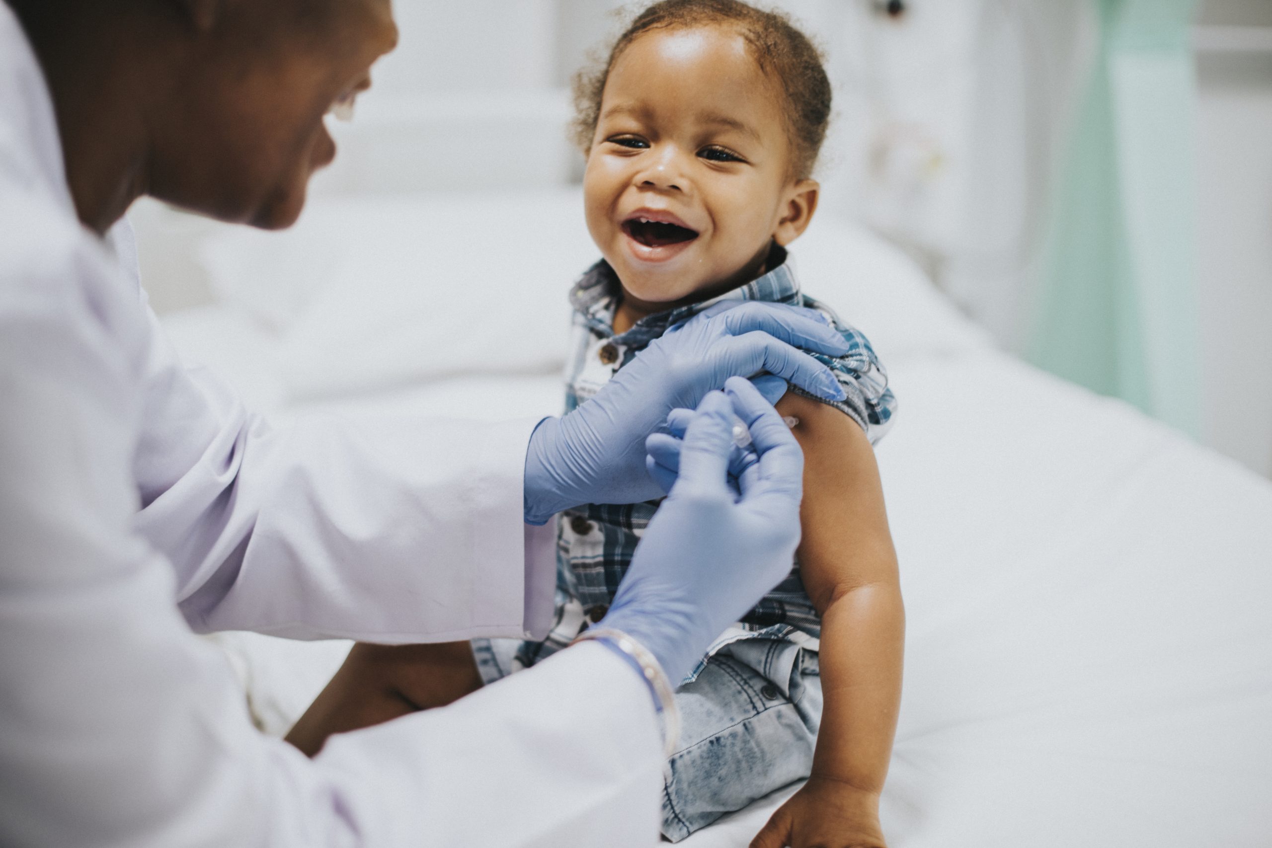 Toddler getting a vaccination by a pediatrician